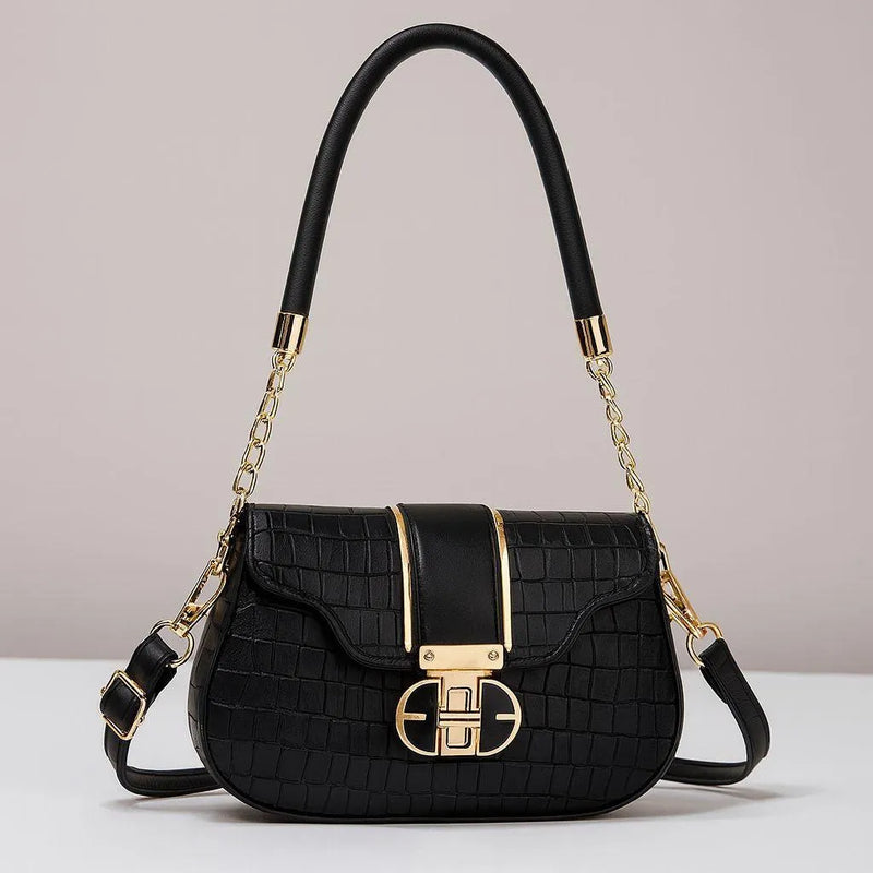 Black handbag with gold accents on a light gray background