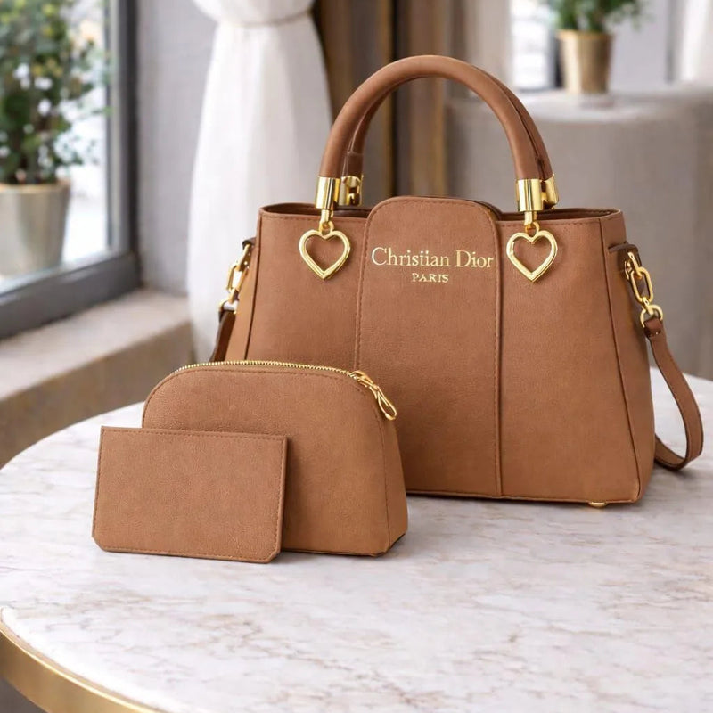 Brown Christian Dior handbag and matching pouch on a marble table.