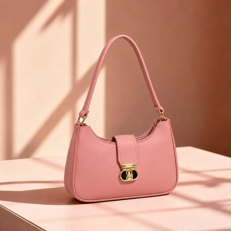 Pink handbag with a gold lock on a pink background